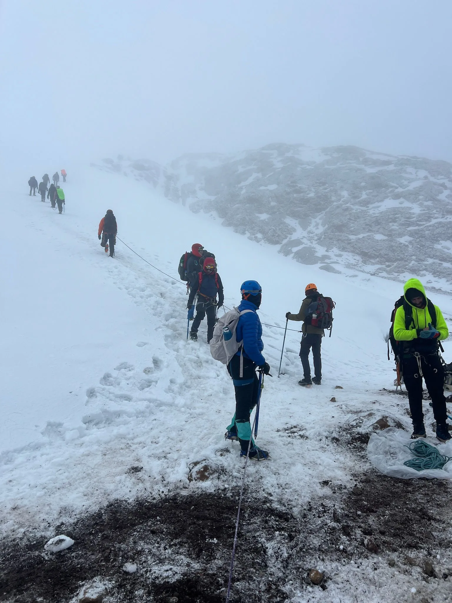 Viajeros caminando juntos por nieve de alta montaña